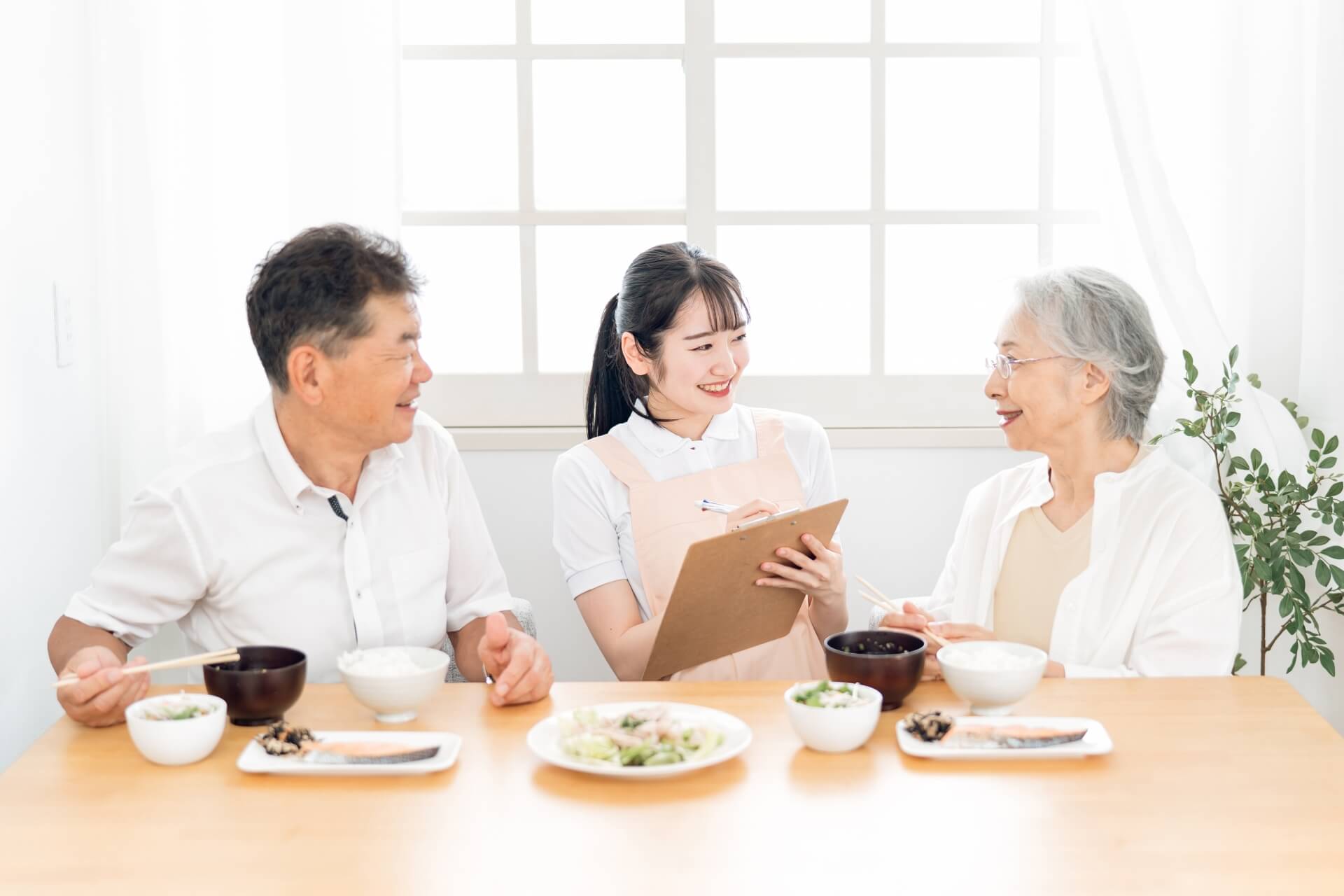 栄養管理をする女性スタッフと高齢者